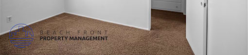 A room with a brown carpet and a white door.