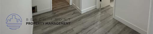 A hallway with a logo for Beach Front Property Management in the bottom left corner.