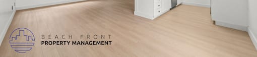 A spacious room with a ceiling fan and wooden flooring, managed by Beach Front Property Management.