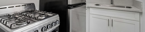 A black refrigerator sits next to a stove in a kitchen.
