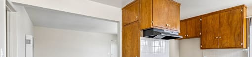 A kitchen with wooden cabinets and a ceiling fan.