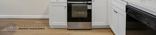 A kitchen with white cabinets and appliances.