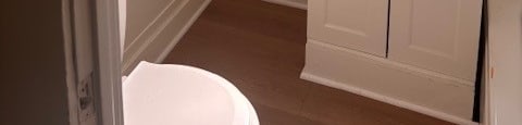 A white bathroom with a toilet, sink, and medicine cabinet.