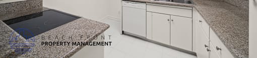 A kitchen with granite countertops and white cabinets.