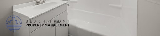 A white bathroom with a sink, mirror, and bathtub.