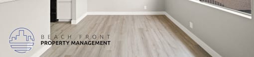 an empty living room and kitchen with wood flooring and a window