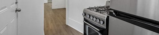 A stainless steel oven in a kitchen with white walls.
