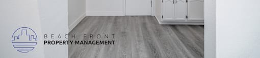 A white bathroom with a fan and a logo for Beach Front Property Management.