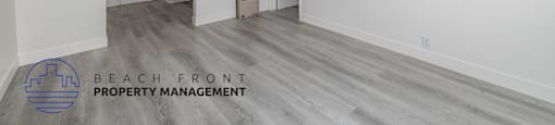 A spacious room with a logo for Beach Front Property Management in the corner.