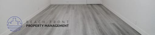 A room with a window and a door, with the logo of Beach Front Property Management on the bottom left.