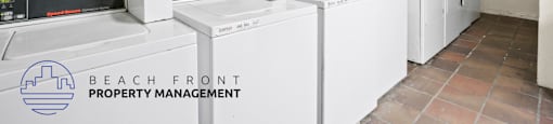 A laundry room with washers and dryers and a sign that says Beach Front Property Management.