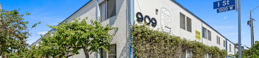 A building with the number 900 on it is shown with a sign that says 1st St 1000 W.