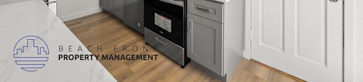 a renovated kitchen with gray cabinets and black appliances