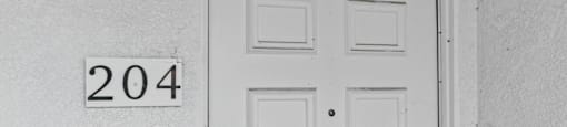 A white door with a number 204 on the wall above it.