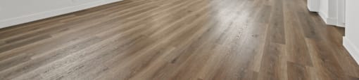A room with a ceiling fan and wooden flooring.