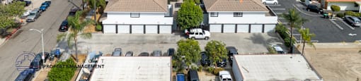 A bird's eye view of a parking lot with a building in the center.
