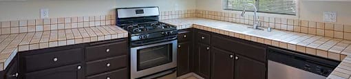 a kitchen with a stove and a sink and a microwave
