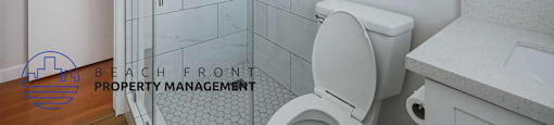 A white toilet in a bathroom with a walk-in shower.