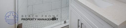 A white bathroom with a sink and a shower.