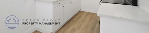 A kitchen with white cabinets and a sink.
