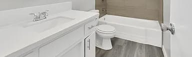 A white bathroom with a toilet, sink, and bathtub.
