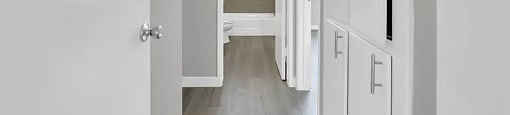 A hallway with white doors and a light on the ceiling.