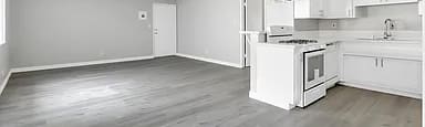 A white kitchen with a grey floor and white cabinets.