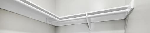 A white shelf is mounted on a white wall.