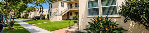 A sunny day in a quiet residential street with apartment buildings on either side.