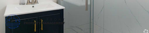 A bathroom with a marble wall and a white sink.
