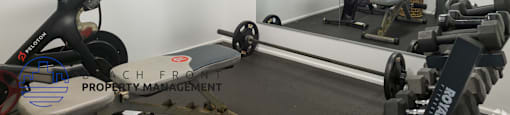 A gym room with a mirror, weights, and exercise equipment.