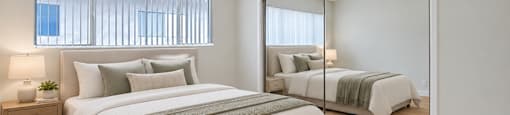 A bedroom with a large bed and a mirror.