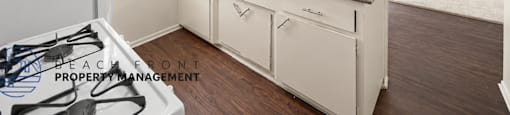 A kitchen with white cabinets and a countertop with a sink.