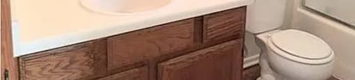 A white sink in a bathroom with a towel on it.