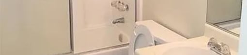 A white bathroom with a toilet, sink, and medicine cabinet.