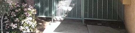 A green metal gate is closed and locked.