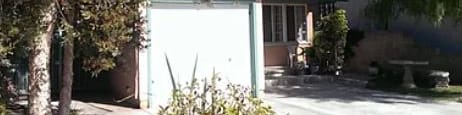 A white garage door is in the middle of a driveway.