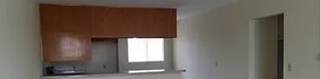 A room with a brown carpet and white walls.