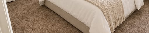 A bedroom with a large bed and a carpeted floor.