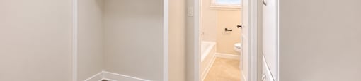 A small bedroom with a bunk bed and a doorway leading to another room.