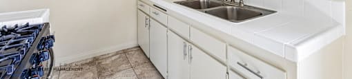 A kitchen with a white countertop and cabinets.