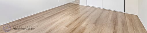 A room with a sliding door and wooden flooring.