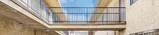 A courtyard with a skylight and a staircase leading to a balcony.