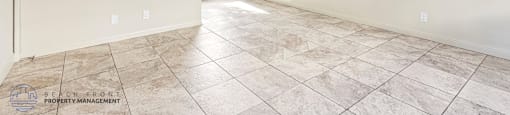 A spacious room with tiled flooring and a ceiling fan.