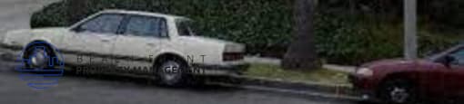 a white car parked in front of a white house
