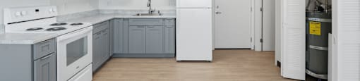 A kitchen with white appliances and grey cabinets.