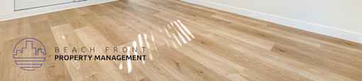 A room with a ceiling fan and wooden flooring.