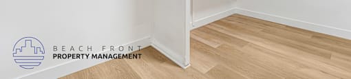 A white closet with shelves and a logo for Beach Front Property Management.
