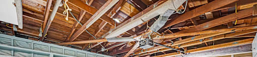 A large, empty room with wooden beams and a concrete floor.