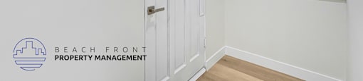 A white door with a yellow sign on it in a room with white walls.